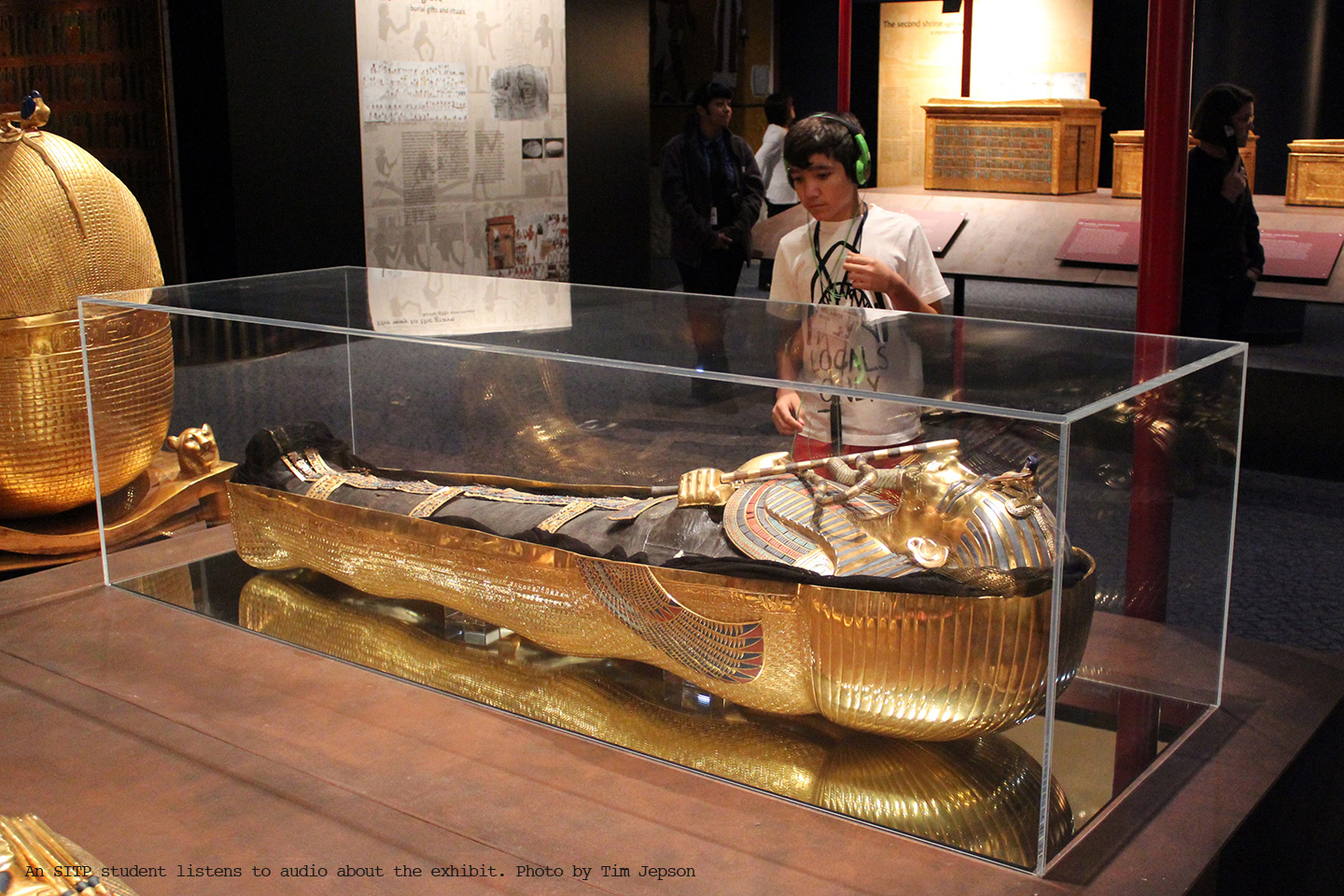 A student listens to audio about an exhibit.